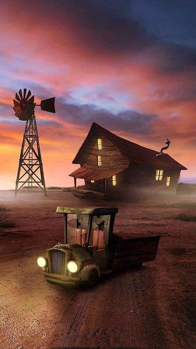 An old farmhouse, windmill and truck under a dramatic orange evening sky.