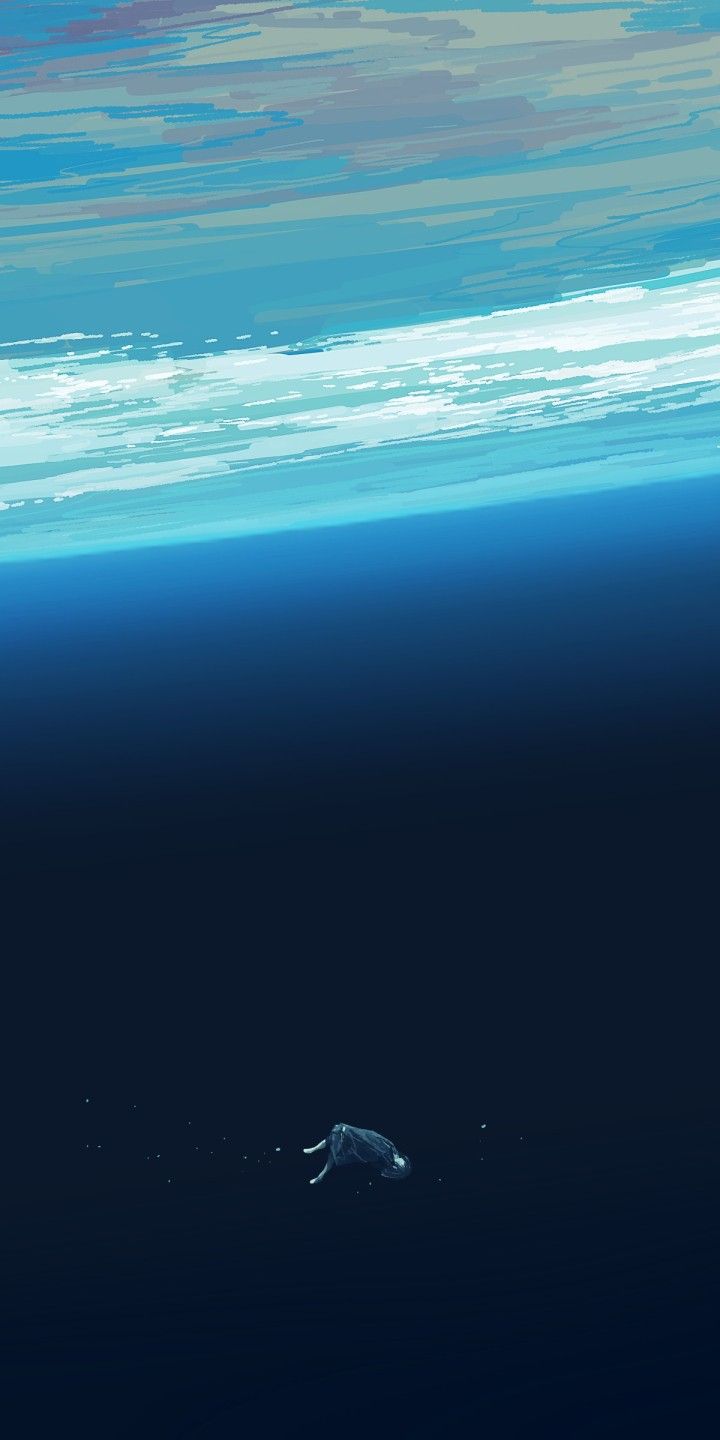 A tiny turtle swimming in deep blue water below a bright sea surface.