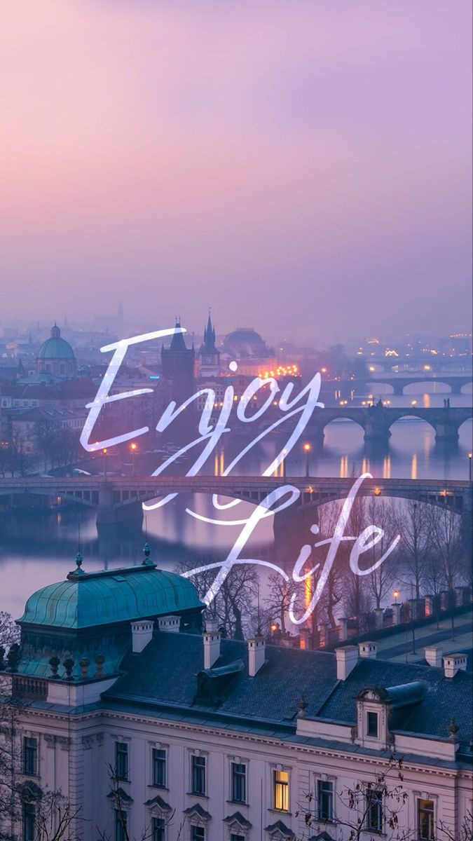 "Enjoy life" in white script over a city riverfront at dusk.