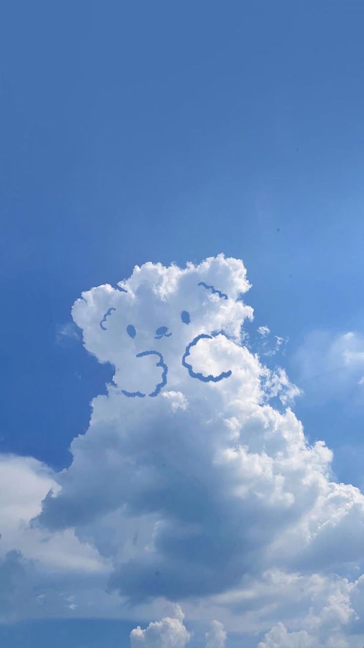 A white cloud shaped like a teddy bear in a clear blue sky.