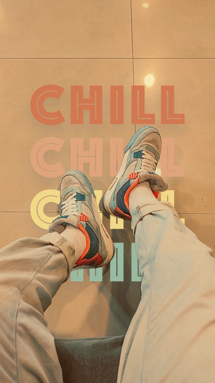 Crossed legs in trainers resting in front of a wall with "Chill" printed over and over in red.