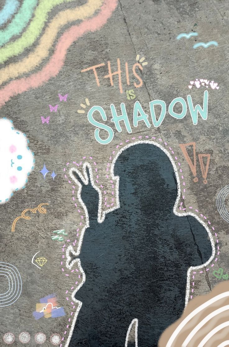 The shadow of a person making a peace sign on pavement, surrounded by chalk doodles and "This shadow".