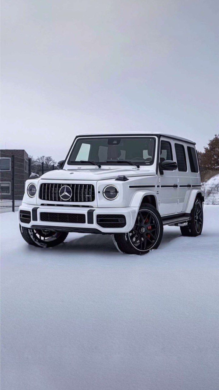 A white Mercedes-AMG G63 in a snowy car park.